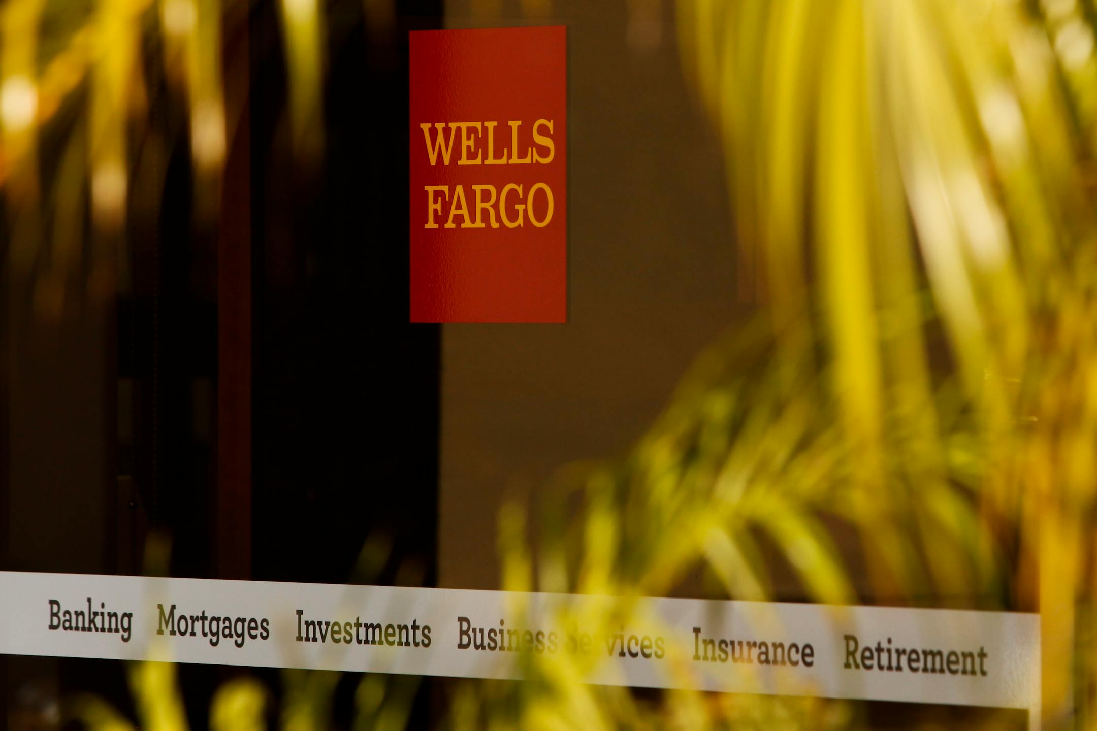 Wells Fargo & Co. signage is displayed in the window of a bank branch in Hermosa Beach, California, U.S., on Tuesday, Sept. 10, 2013. Mortgage applications in the U.S. plunged last week to the lowest level in almost five years as rising borrowing costs led to a slump in home refinancing. Photographer: Patrick T. Fallon/Bloomberg