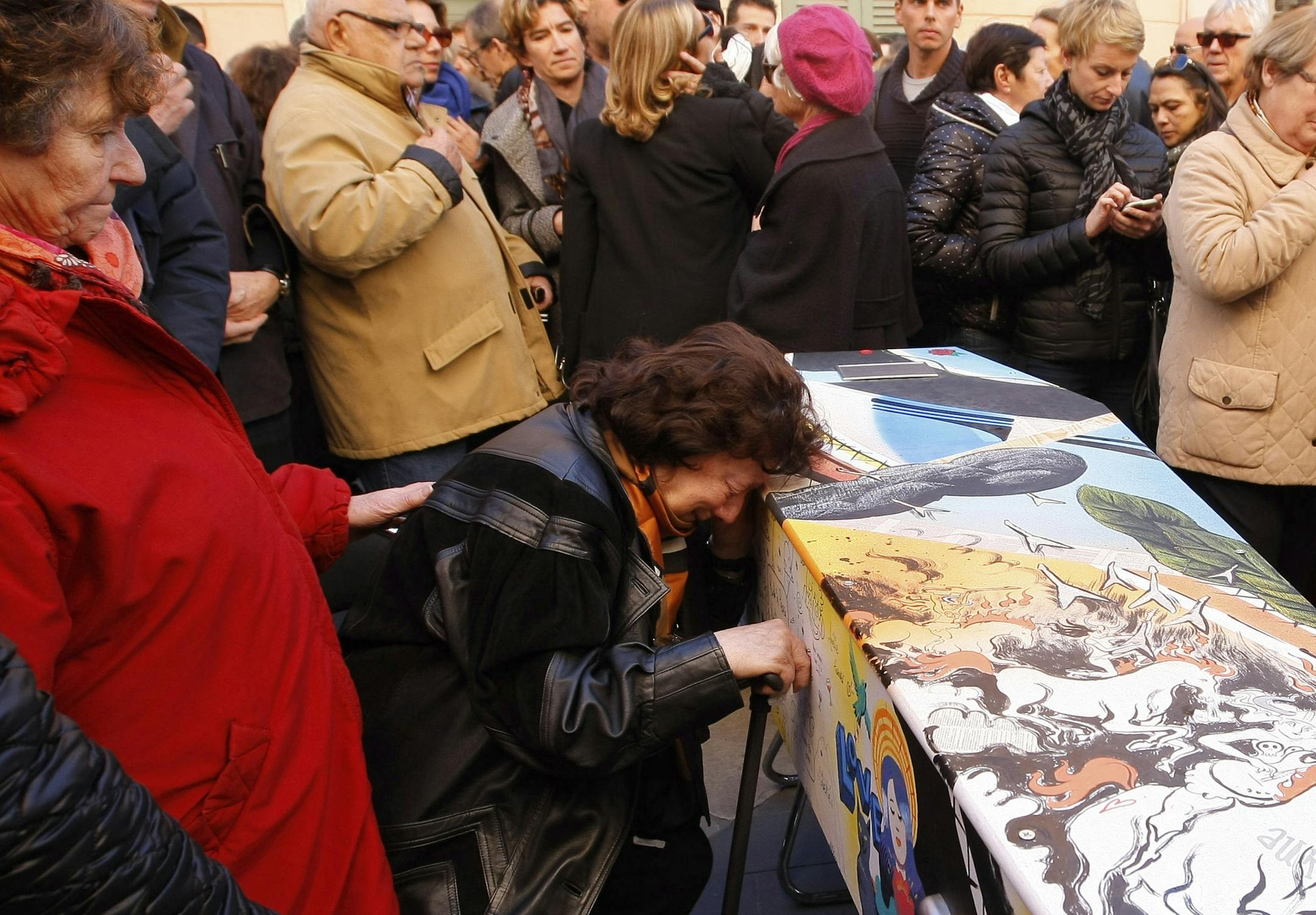 An unidentified woman grieves at the coffin of France's Aurelie de Peretti, who was killed at the Bataclan concert hall during the Paris attacks, Thursday, Nov.26 2015 in Saint-Tropez, French Riviera. French lawmakers voted Wednesday to continue airstrikes in Syria against the Islamic State group that claimed responsibility for the Nov. 13 attacks that killed 130 people in Paris. (AP Photo/Claude Paris)