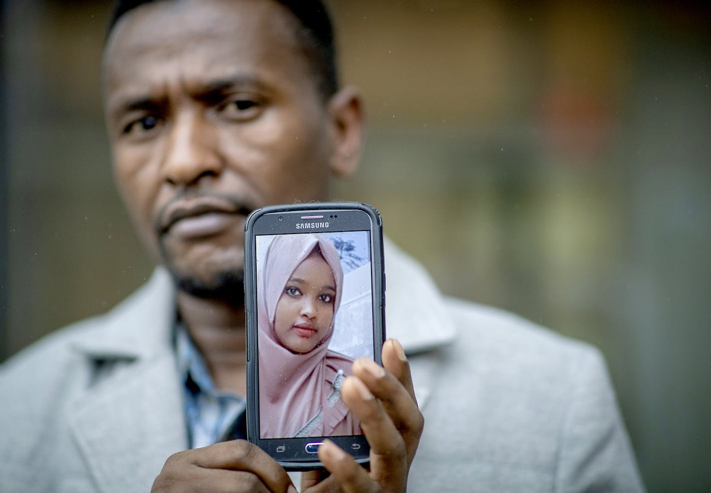 Hasan Sharif held up a photo of his 14-year-old daughter, Mustariya, whose flight from Eritrea was canceled.