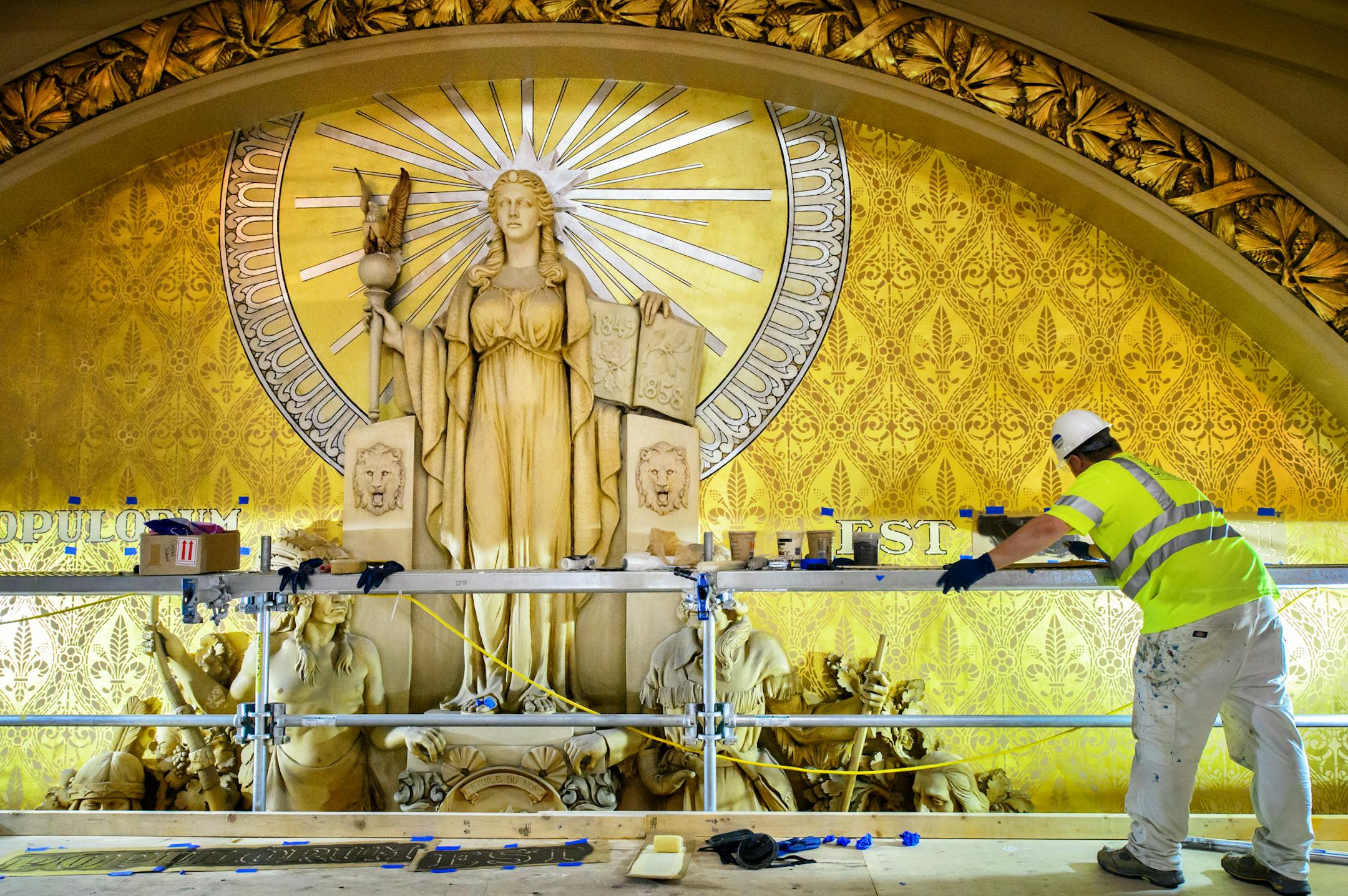 Workers from Conrad Schmitt Studios, a restoration company out of New Berlin, Wisconsin, are painstakingly restoring the murals and gold leaf on the upper level of the Minnesota House Chamber. Here the lettering of Vox Populorum Est Vox Dei is being cleaned and restored. It translates to The Voice of the People is the Voice of God. ] GLEN STUBBE * gstubbe@startribune.com Thursday September 10, 2015
