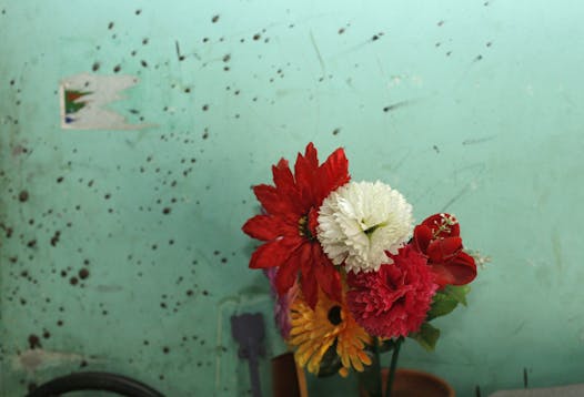 An artificial flower pot is seen next to a blood-stained wall at the home of blogger Niloy Chowdhury, who was hacked to death by unknown assailants in Dhaka, Bangladesh, Friday, Aug. 7, 2015. Assailants believed to be Islamist militants entered an apartment building posing as potential tenants and killed the secular blogger in Bangladesh's capital on Friday, the fourth such deadly attack this year, police said.