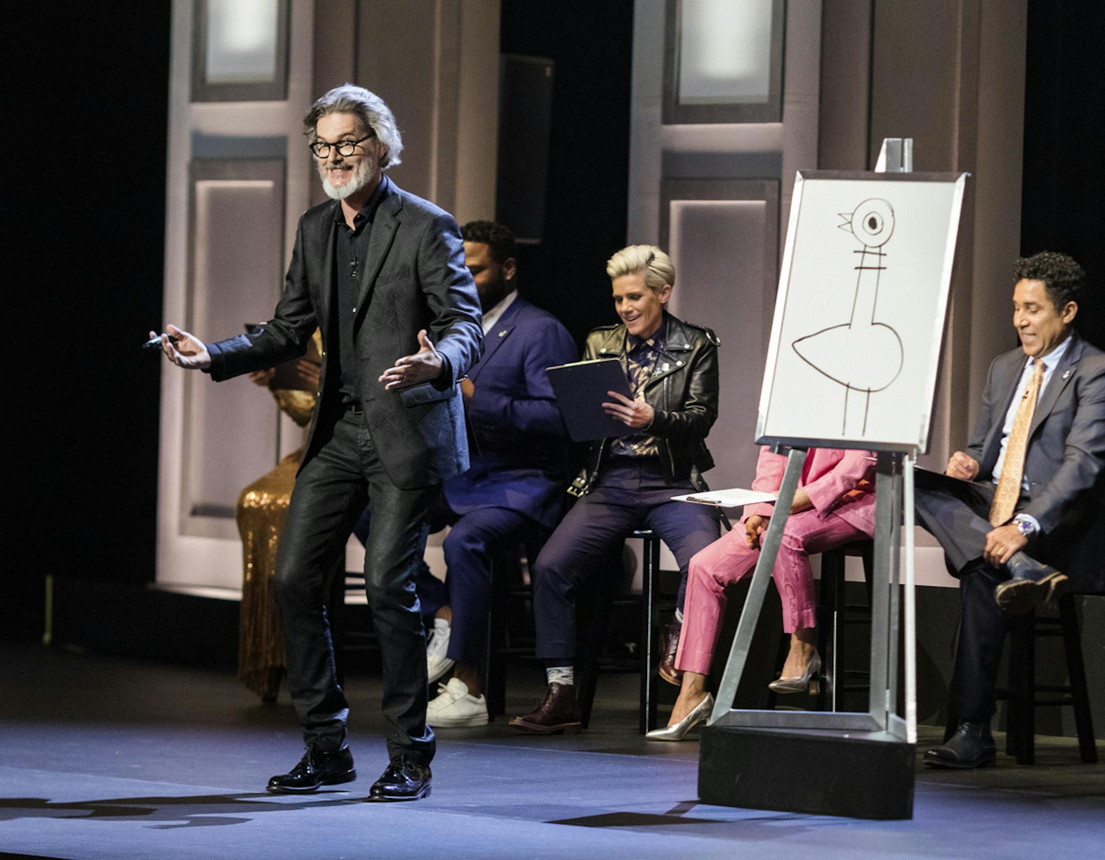 This image released by HBO Max shows author and illustrator Mo Willems, standing, in "Don't Let the Pigeon Do Storytime!" The special was filmed last year at the Kennedy Center and features comedy inspired by Willems' books for children. (HBO Max via AP)