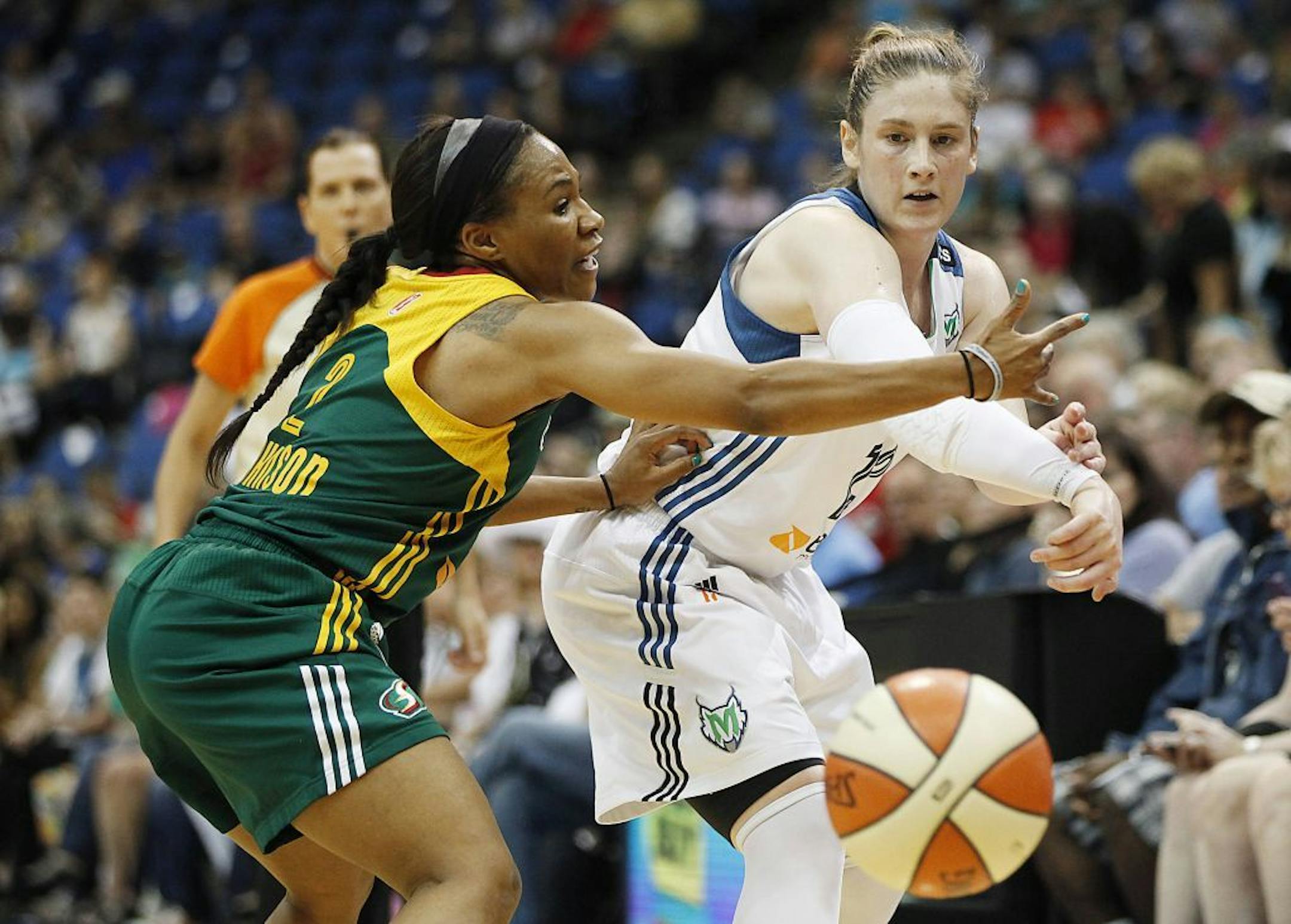 Minnesota Lynx guard Lindsay Whalen, right, passes through the defense of Seattle Storm guard Temeka Johnson (2) in the first half of a WNBA basketball game on Saturday, Aug. 31, 2013, in Minneapolis.