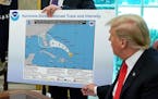 President Donald Trump references a map while talking to reporters in the Oval Office Wednesday, Sept. 4, 2019. The map was a forecast from August 29 