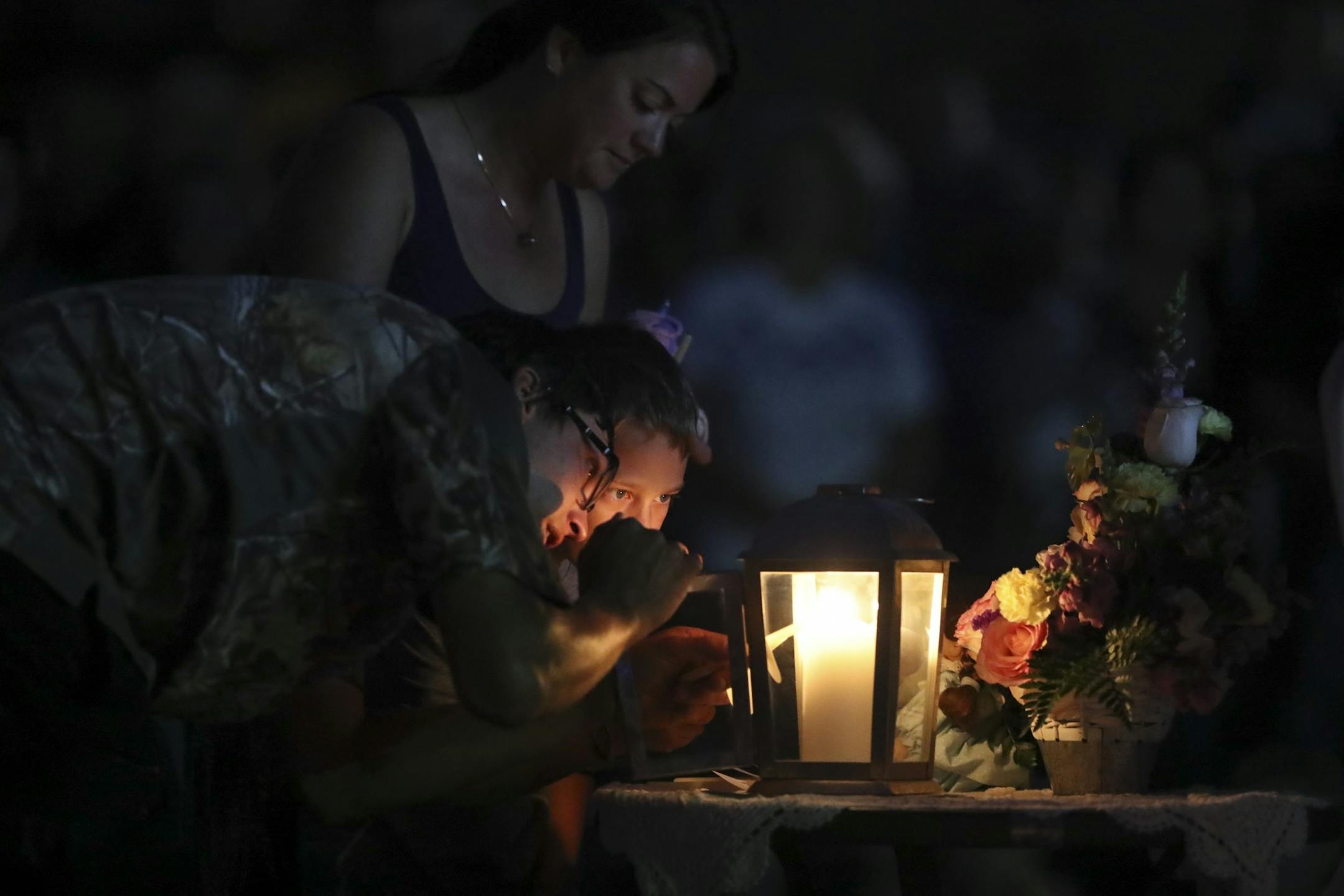 The family of Alayna Ertl, her parents Matt and Kayla and older brother, Carter, lit their candles first during the prayer vigil for Alayna Ertl Tuesday night in the parking lot of St. Anthony Church in Watkins.