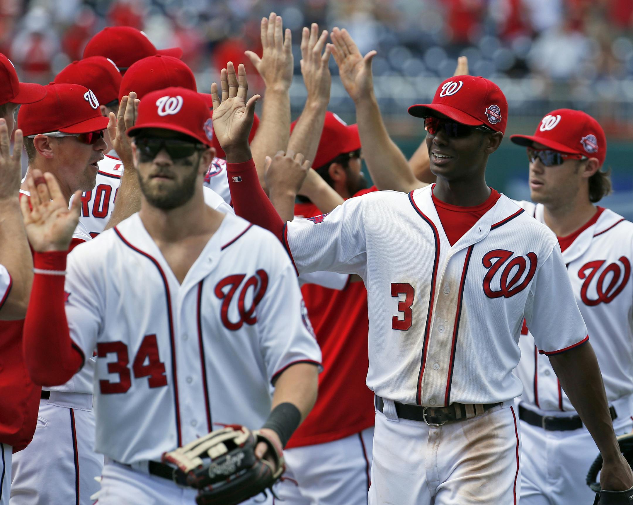 Washington Nationals' Bryce Harper (34) and Michael Taylor (3) celebrate after a baseball game against the New York Mets at Nationals Park, Wednesday, July 22, 2015, in Washington. Taylor drove in two runs and scored the winning run. The Nationals won 4-3. (AP Photo/Alex Brandon)