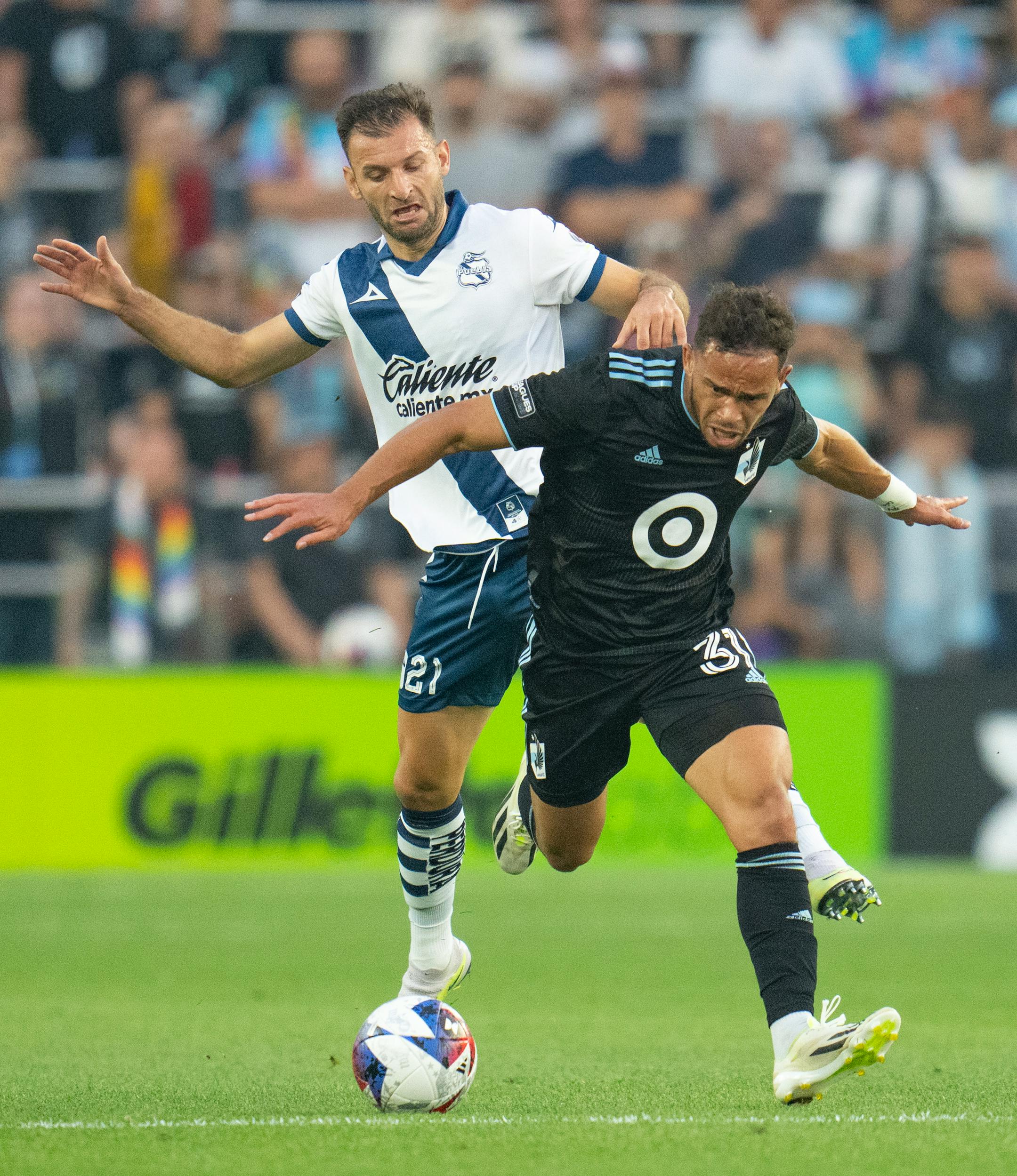 Puebla defender Gastón Silva (21) pressures Minnesota United midfielder Hassani Dotson (31) in the first half of a Leagues Cup match Sunday at Allianz Field St. Paul.