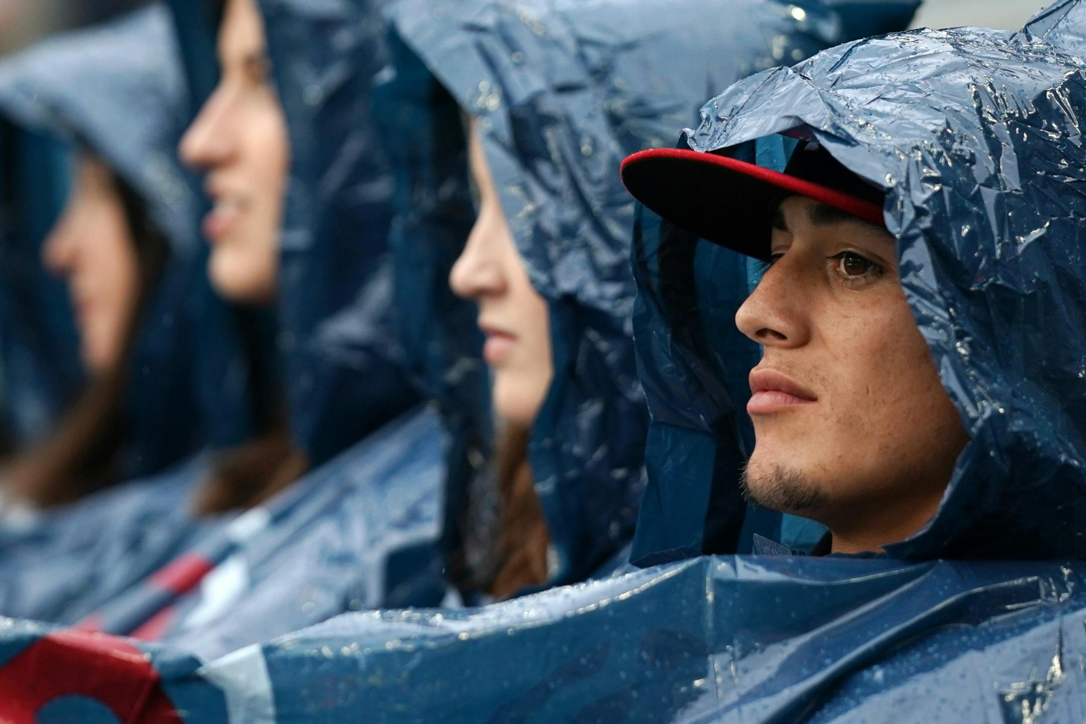 David Alcantar of Tulare, Calif. watched from under a Minnesota Twins rain poncho during a rain delay Friday at Target Field.