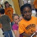 Osseo Elementary fifth-grader Maddie Miller signed second-grader Takyezia Lee's T-shirt during some free time after the final school assembly. Not onl