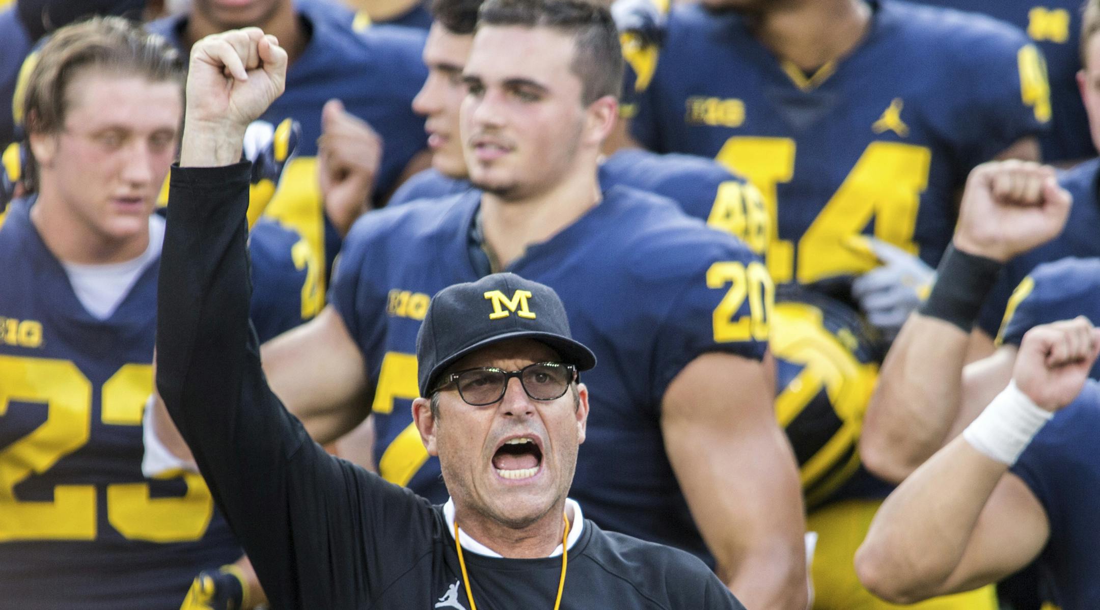 FILE - In this Aug. 26, 2018, file photo, Michigan head coach Jim Harbaugh leads his players and fans in singing "Hail to the Victors" after a practice session by the NCAA college football team at Michigan Stadium in Ann Arbor, Mich. Jim Harbaugh enters his sixth season as Michigan's coach with just two years left on his contract, adding another layer of interest in the 18th-ranked Wolverines as they kick off the season this week at No. 21 Minnesota.(AP Photo/Tony Ding, File) ORG XMIT: MERd0ee79