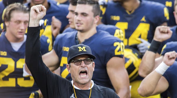 FILE - In this Aug. 26, 2018, file photo, Michigan head coach Jim Harbaugh leads his players and fans in singing "Hail to the Victors" after a practic