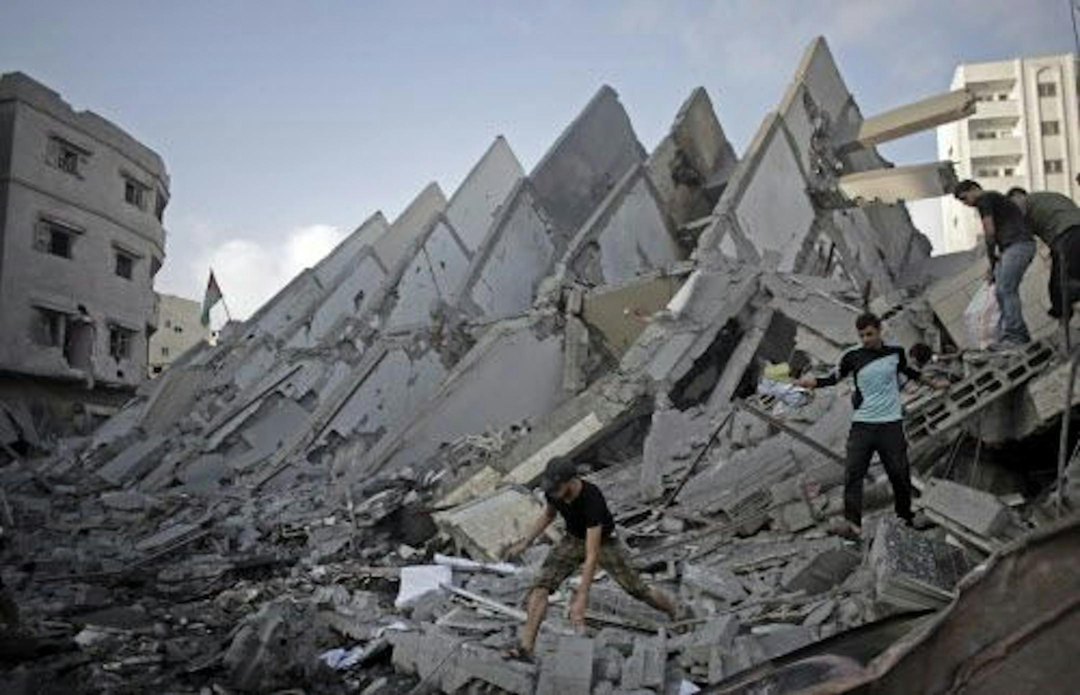 Palestinians salvage items from the rubble of the destroyed 15-story Basha Tower, following early morning Israeli airstrikes in Gaza City, Tuesday, Aug. 26, 2014.