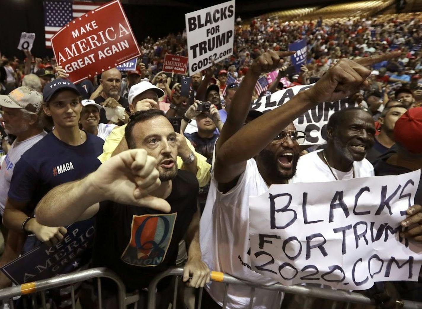 FILE In this Tuesday, July 31, 2018, file photo, supporters of President Donald Trump shout down a CNN news crew before a rally in Tampa, Fla. Amid the "Trump 2020" placards, the "Women for Trump" signs and the "CNN SUCKS" T-shirts, the most inscrutable message that came out of Donald Trump's Tampa rally on Tuesday evening was a letter, Q.