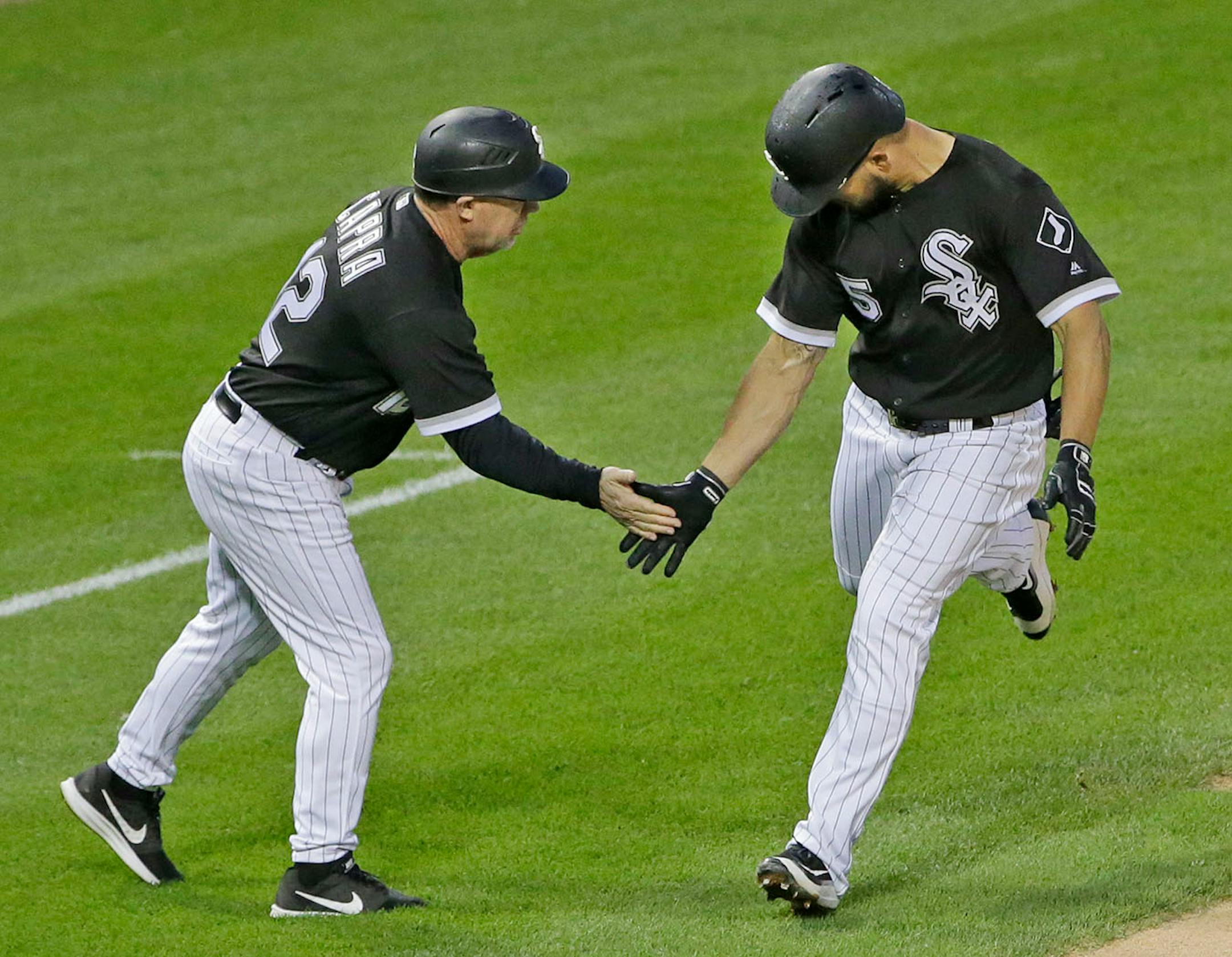 Chicago White Sox's Yolmer Sanchez, right, celebrates with third base coach Nick Capra after hitting a solo home run during the second inning of a baseball game against the Minnesota Twins, Thursday, Aug. 24, 2017, in Chicago.