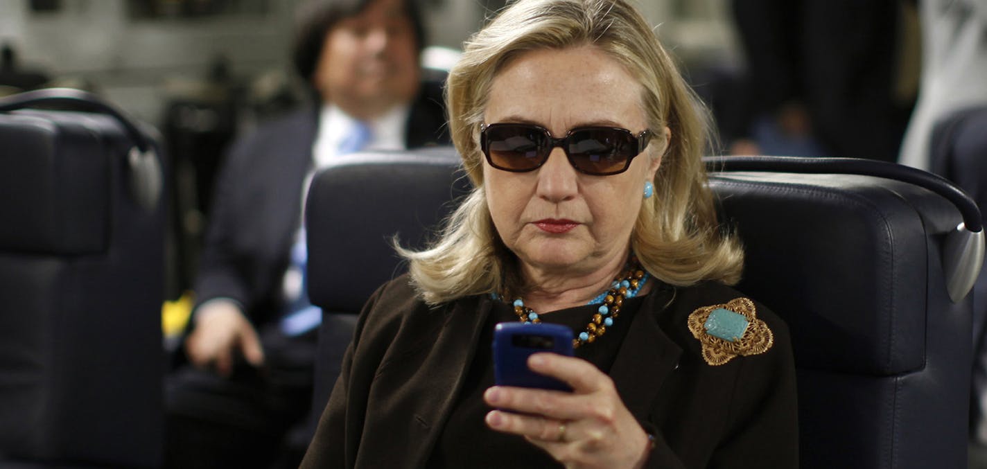 FILE - In this Oct. 18, 2011, file photo, then-Secretary of State Hillary Rodham Clinton checks her Blackberry from a desk inside a C-17 military plane upon her departure from Malta, in the Mediterranean Sea, bound for Tripoli, Libya. The Obama administration is confirming, Friday, Jan. 29, 2016, for the first time that Hillary Clinton's unsecured home server contained some closely guarded secrets, including material requiring one of the highest levels of classification. (Kevin Lamarque/Pool Pho