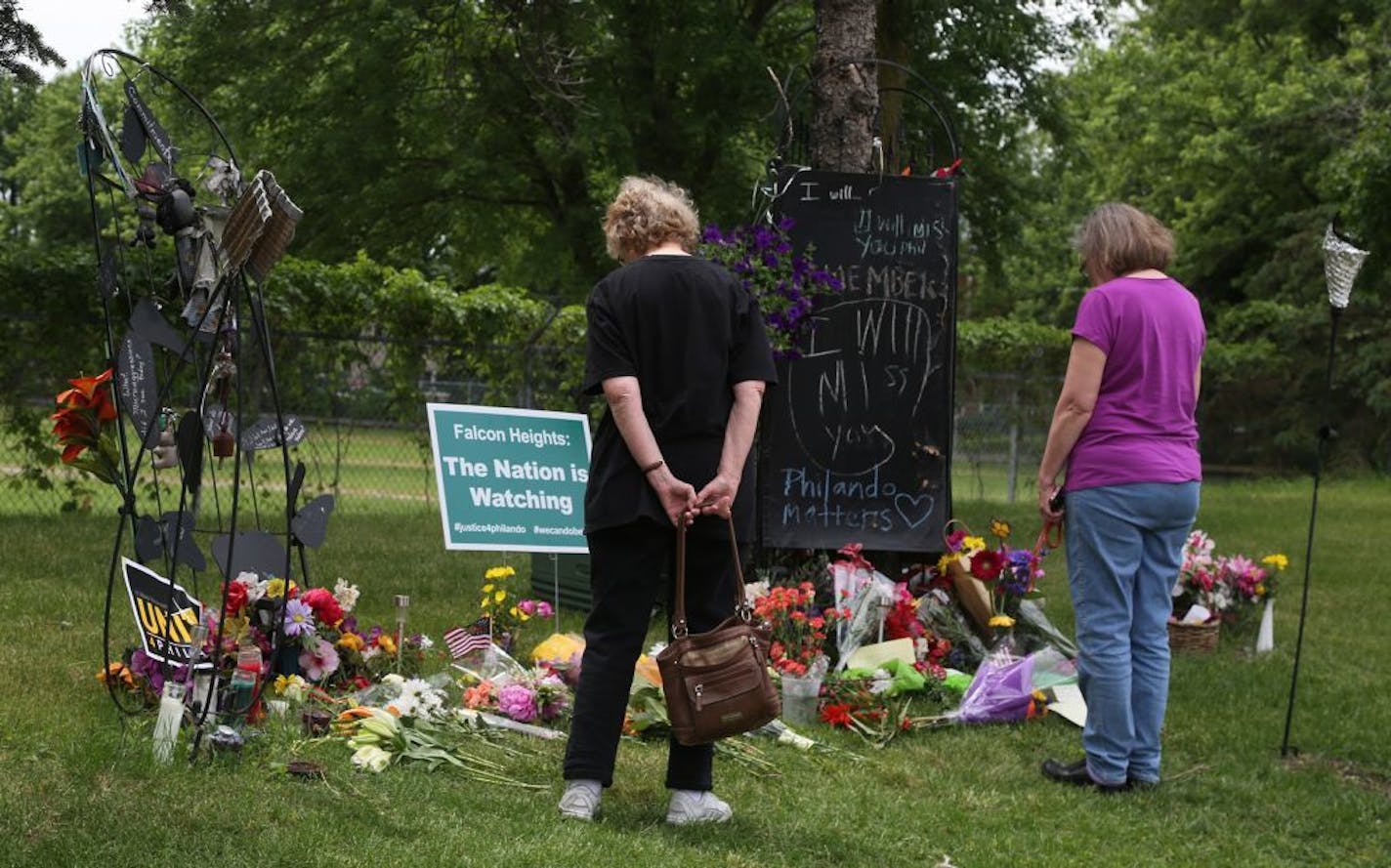 Friends Maureen Smith, left, and Constance Gruen, both of Roseville, look over the notes and flowers near the site where Philando Castile was fatally shot during a traffic stop by St. Anthony police Officer Jeronimo Yanez last July and seen Saturday, June 17, 2017, in Falcon Heights, MN. Yanez was acquitted of all charges in a verdict at the Ramsey County Courthouse Friday.