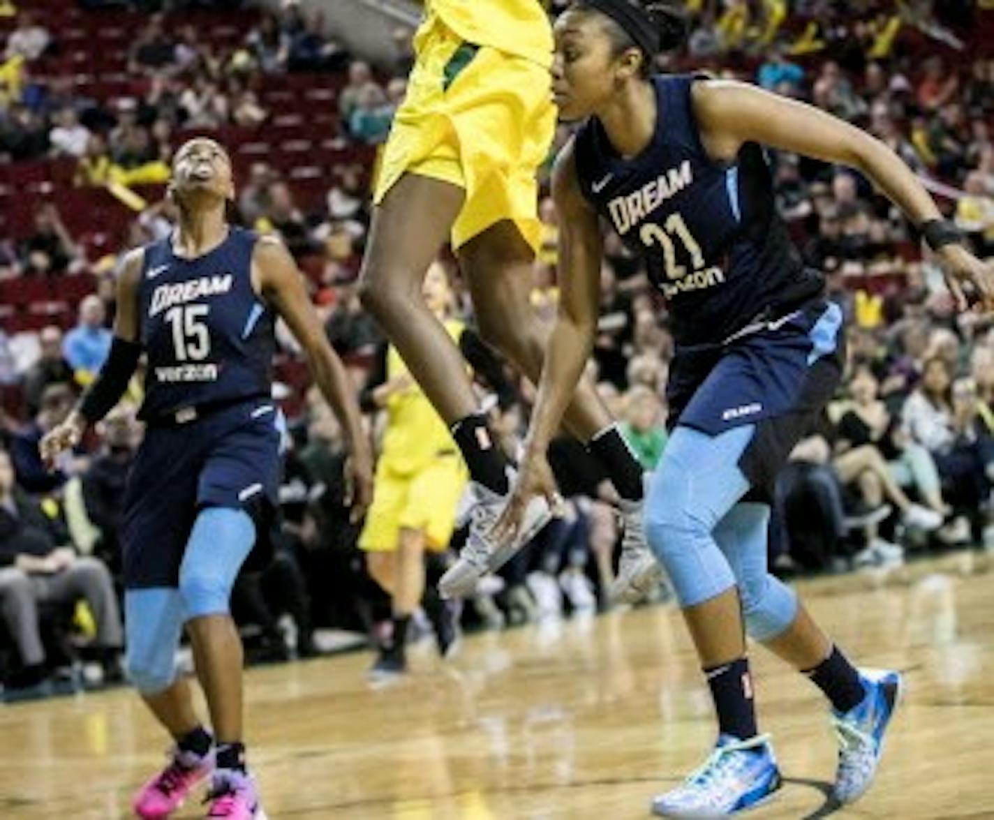 FILE - In this June 10, 2018, file photo, Seattle Storm forward Natasha Howard puts in a layup over Atlanta Dream guards Tiffany Hayes and Renee Montgomery, right, during the second half of a WNBA basketball game in Seattle. Almost every WNBA team this season will go through a hellacious road trip because of the FIBA World Cup in September that is compacting the season.  Atlanta is in the midst of its difficult stretch, playing in six different cities across the country in the past week and a half. (Bettina Hansen/The Seattle Times via AP, File)