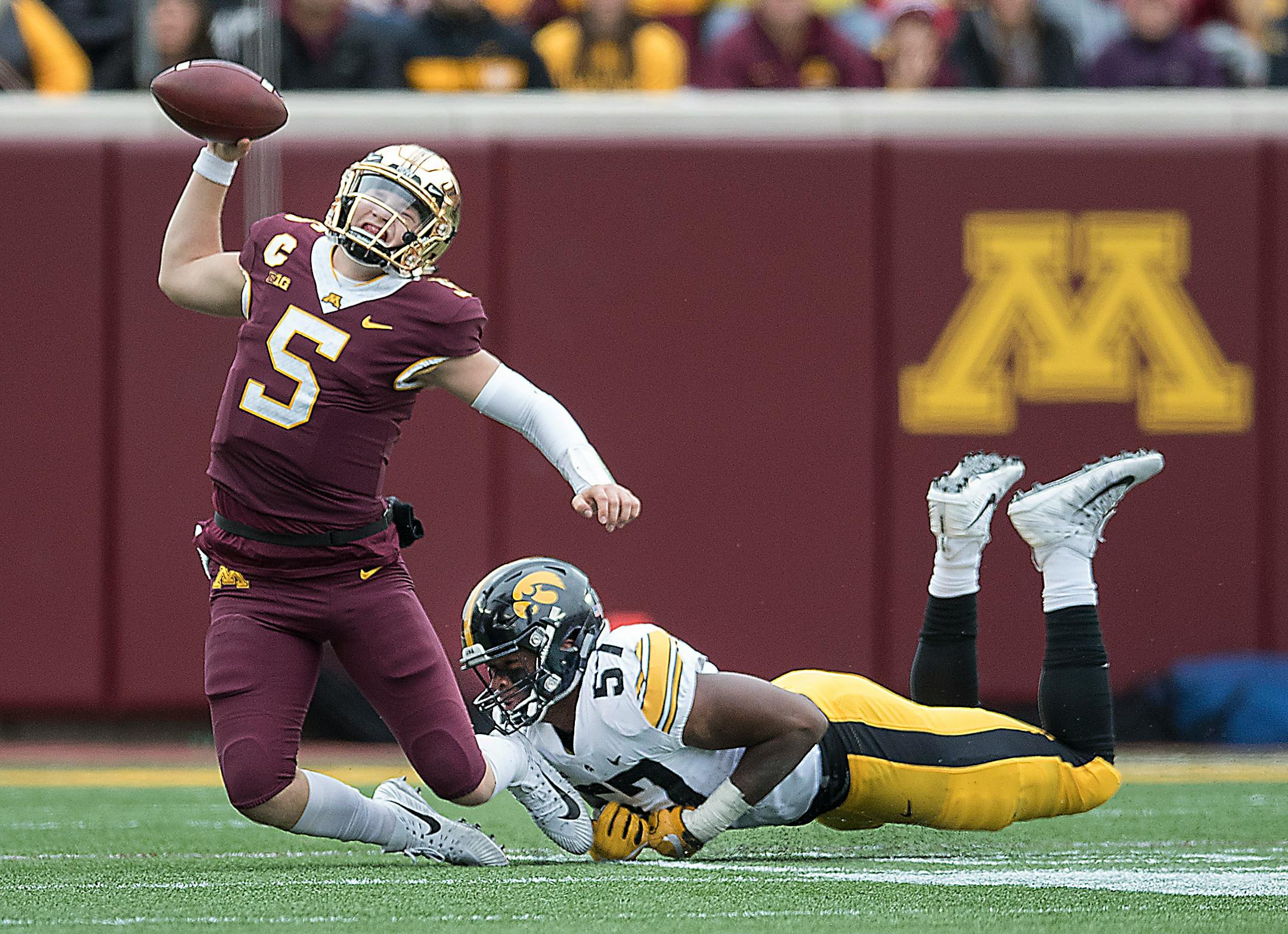 Minnesota quarterback Zack Annexstad was sacked by Iowa's Chauncey Golston during the second quarter