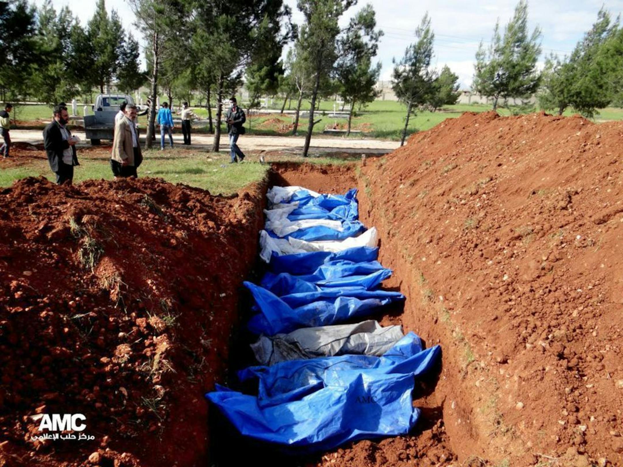 FILE - This Wednesday, April 17, 2013 file citizen journalism image provided by Aleppo Media Center AMC which has been authenticated based on its contents and other AP reporting, shows a mass burial of people allegedly killed by Syrian Army snipers, in Aleppo, Syria.