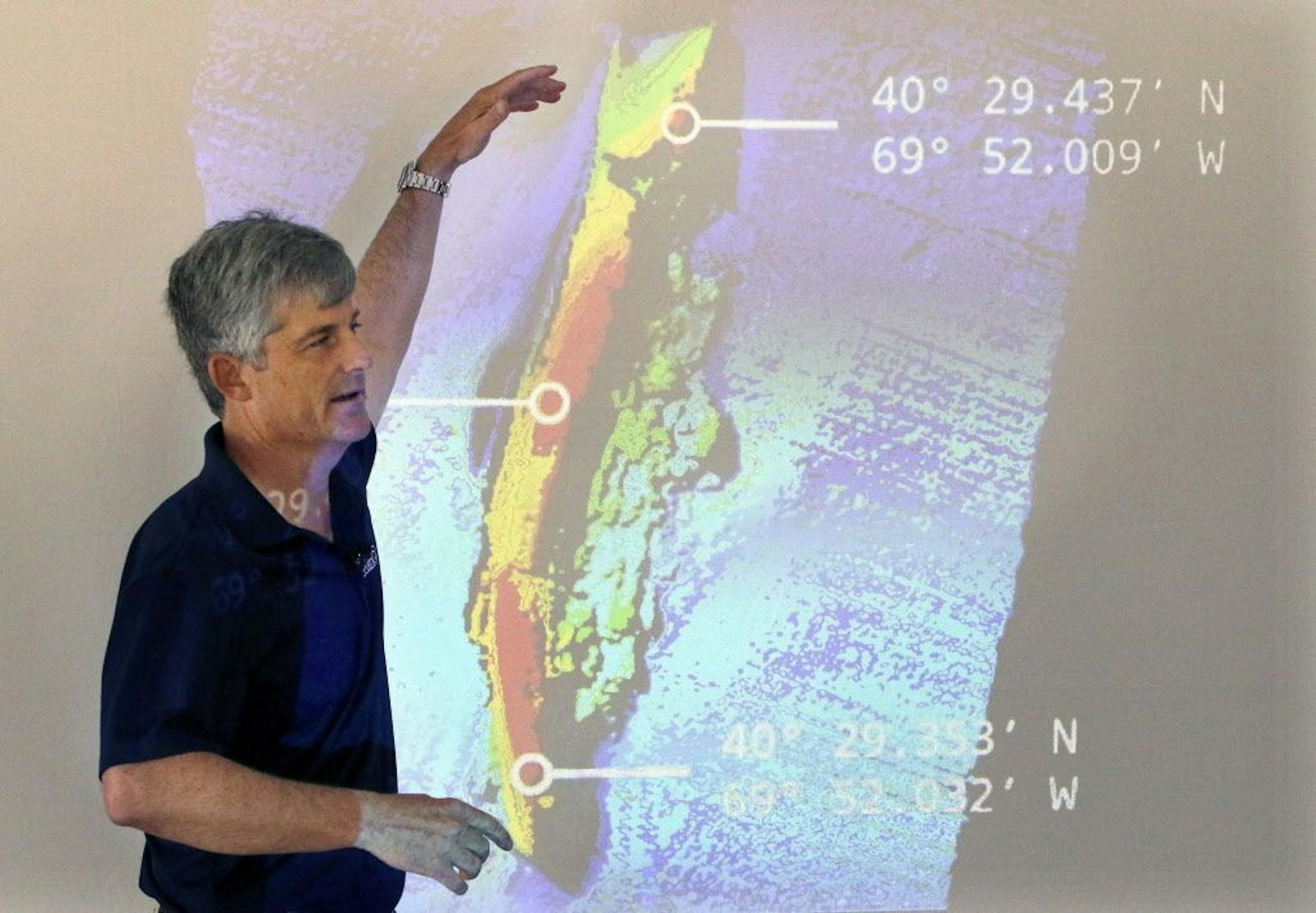OceanGate CEO and co-founder Stockton Rush speaks in front of a projected image of the wreck of the ocean liner SS Andrea Doria during a presentation on Monday, June 13, 2016, in Boston, of findings after an undersea exploration earlier this month of the wreck in the Atlantic Ocean near Nantucket. The ship went down after a collision nearly 60 years ago, killing 46.