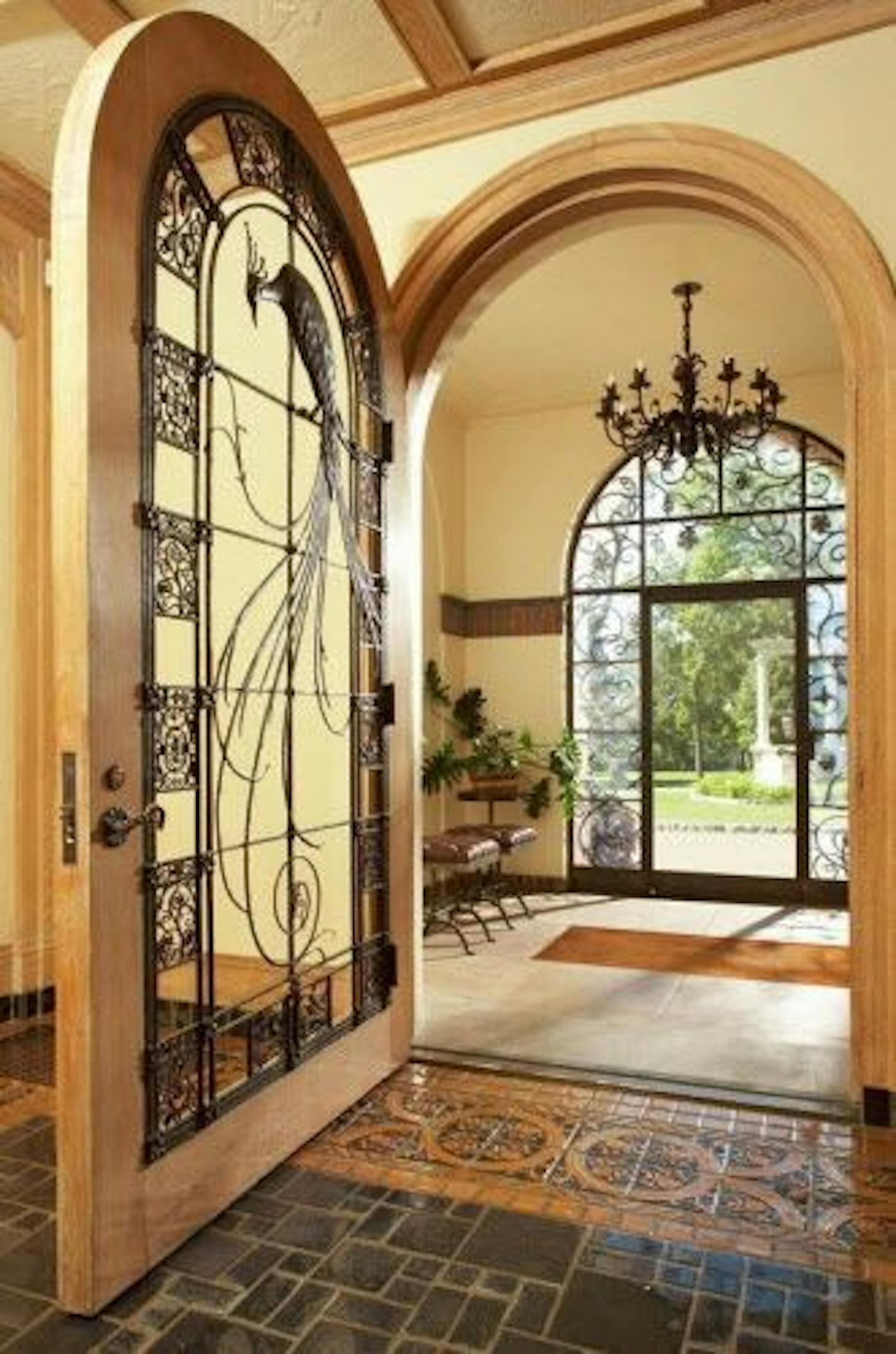 The wrought-iron entry door features a peacock motif.