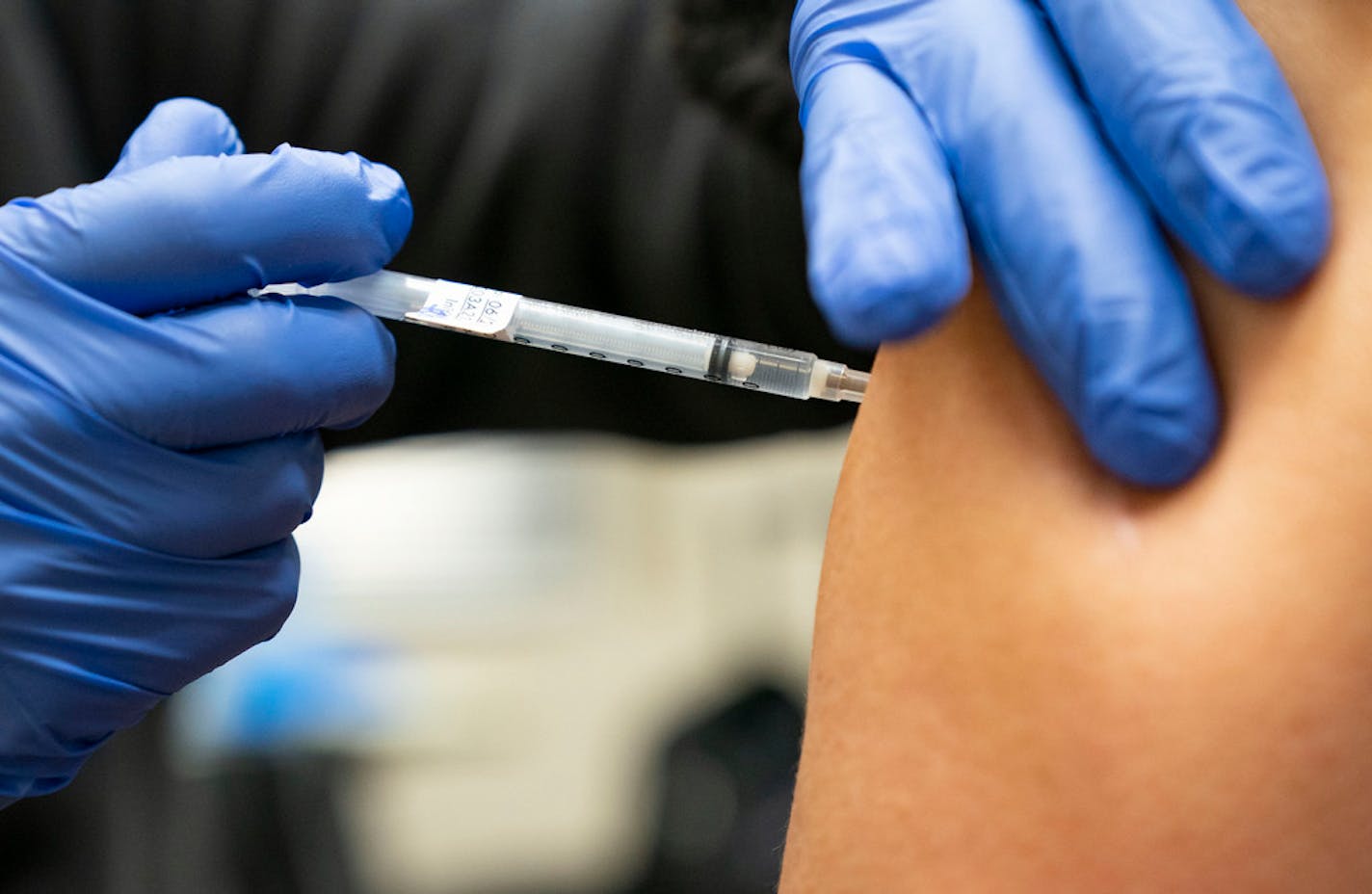 Jeff Smith, a registered nurse, administered a COVID-19 vaccine at the St. Louis County mobile vaccine clinic on Wednesday. ]