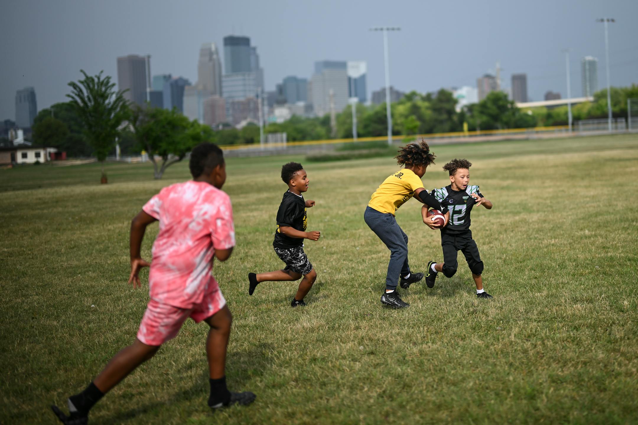 Randy Donnerson III, 6, far right, rushes the ball while playing with teammates before practice.