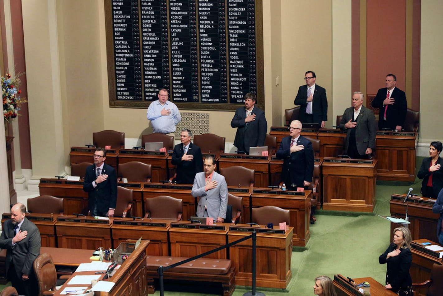 Lawmakers doing social distancing in the Minnesota House take the Pledge of Allegiance, Thursday, March 26, 2020 at the State Capitol in St. Paul.