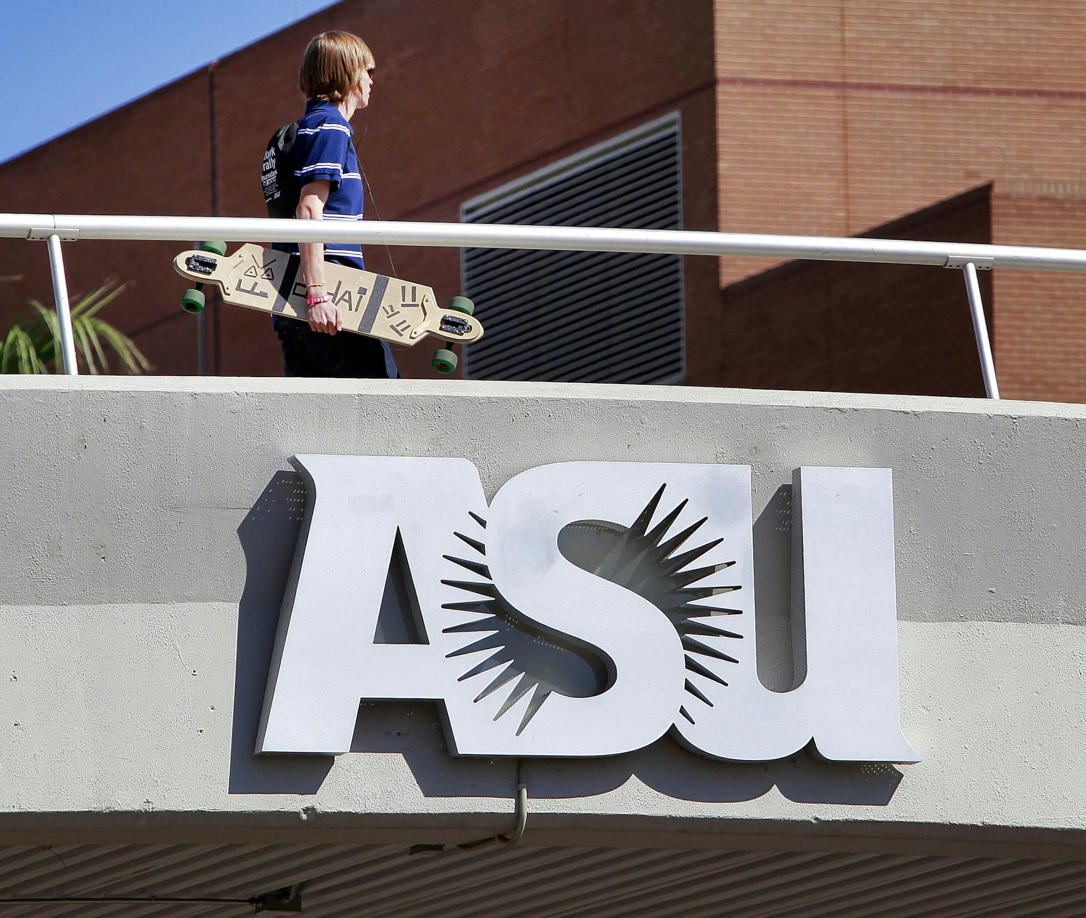 A student walks over Univeristy Ave on the Arizona State University campus Thursday, Sept. 23, 2010 in Tempe, Ariz. The Arizona Board of Regents is scheduled to vote on a proposal to cut back on scholarships for students who perform well on the state's high school graduation test. The universities say the scholarships are costing millions that should be spent on students with financial needs (AP Photo/Matt York) ORG XMIT: AZMY102