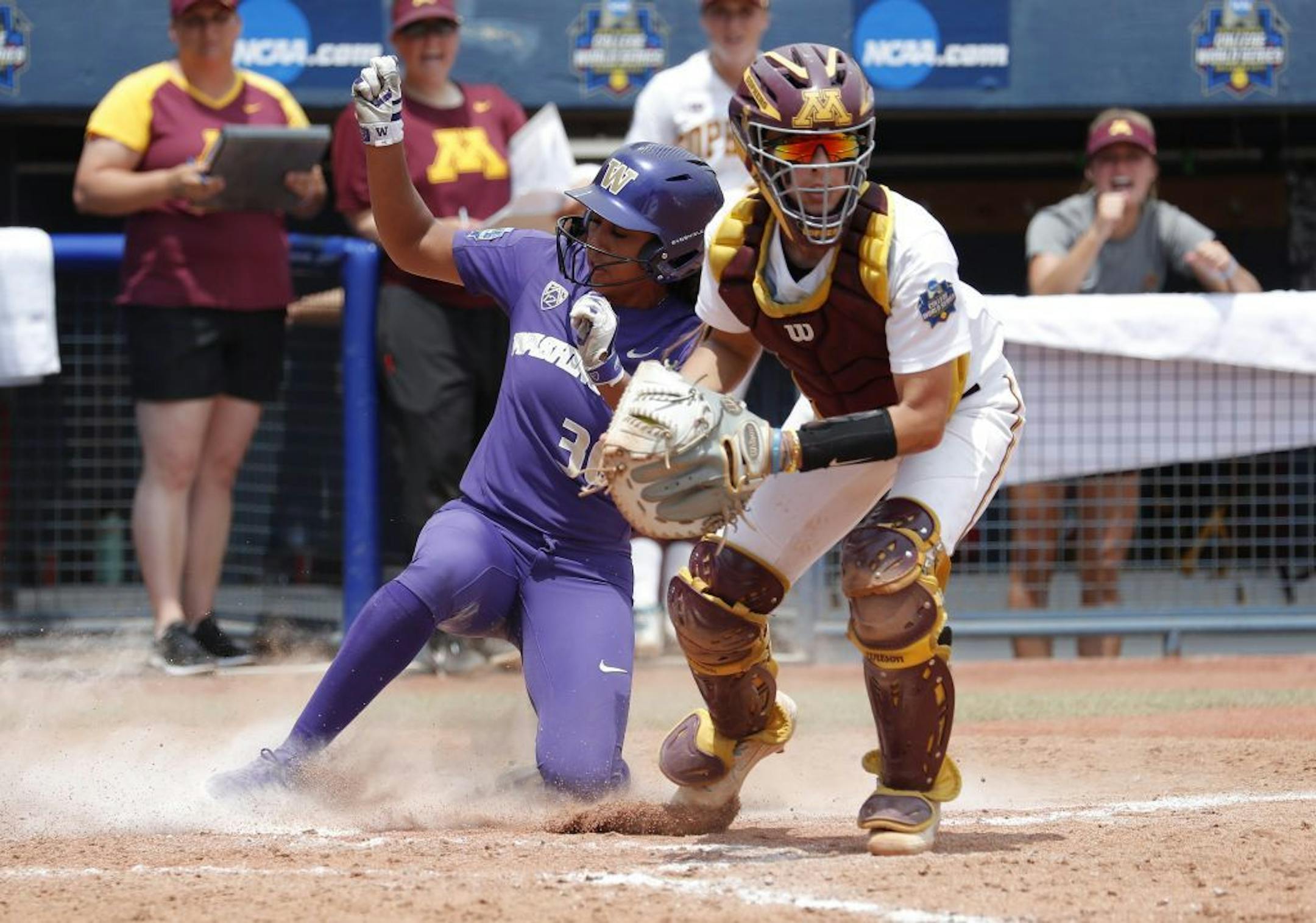 Minnesota catcher gets the out at home against WashingtonÕs Amirah Milloy then eyes first base during the Women's College World Series at ASA Hall of Fame Stadium in Oklahoma City on Saturday, June 1, 2019. Photo by: Alonzo J. Adams