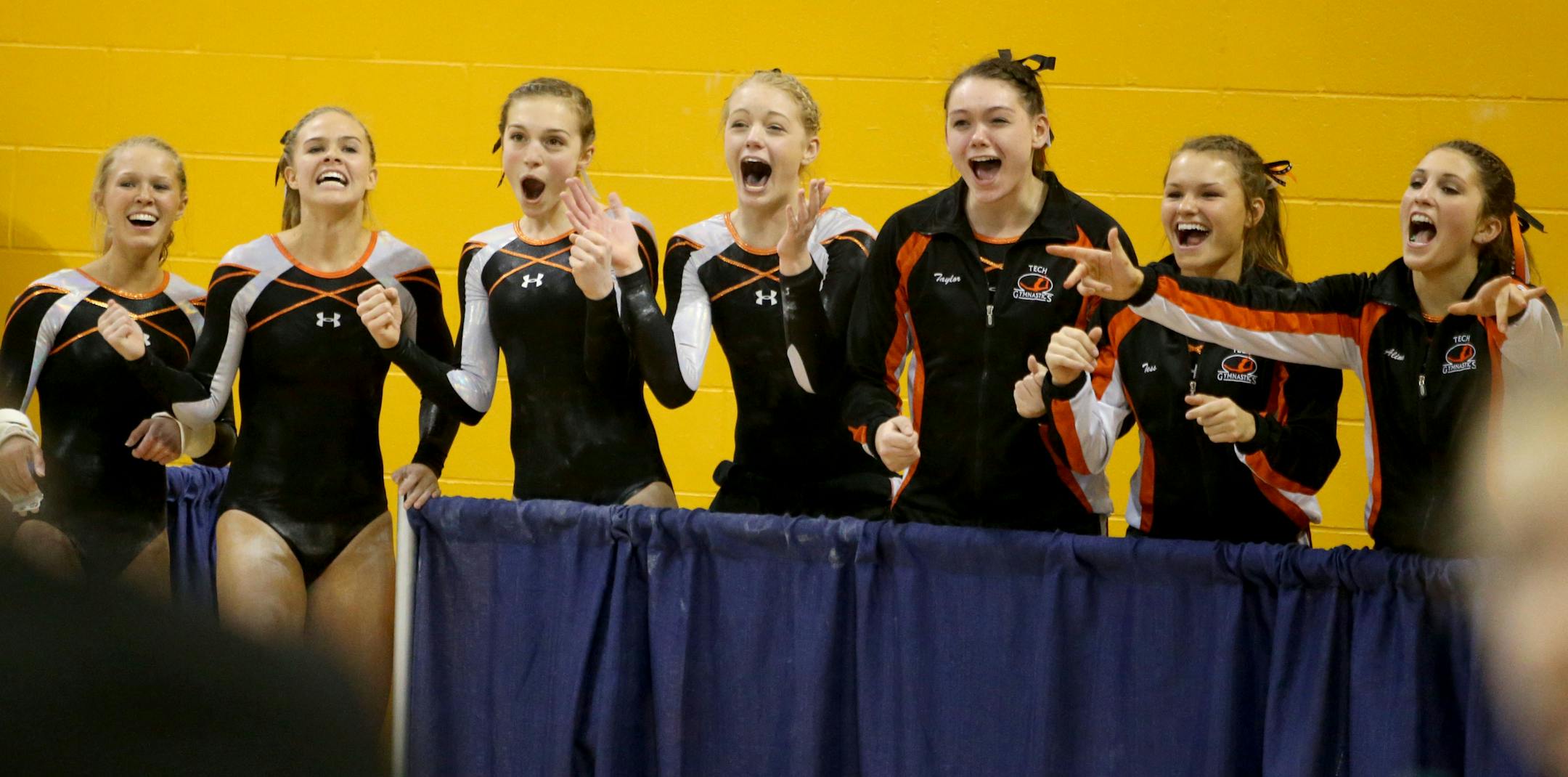 St. Cloud Tech gymnists react to the performance by teammate Lara Aycock on the uneven parallel bars (David Joles, Star Tribune)