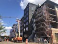 Construction on the Nolan Mains apartments near 50th and Halifax continue, slowing traffic for shoppers in Edina. (Zoe Jackson/Star Tribune)