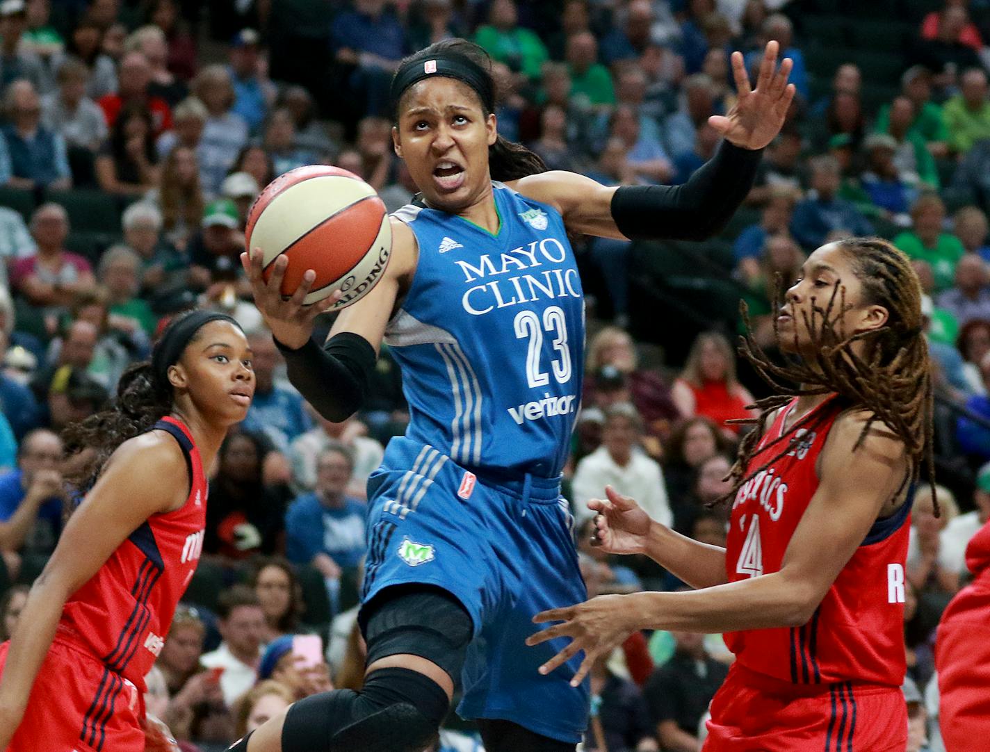 Maya Moore drove between Washington defenders Tayler Hill, left, and Tierra Ruffin-Pratt on Friday. Moore had 22 points.