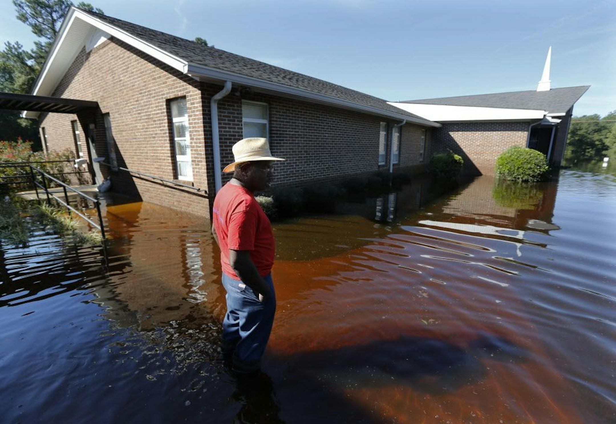 Harold Ancrum, a church member at Canaan United Methodist Church, checks on the floodwaters at the church near Summerville, S.C., Thursday, Oct. 8, 2015. The church had some caskets come out of the ground at their cemetery beside the church during the flooding this week.