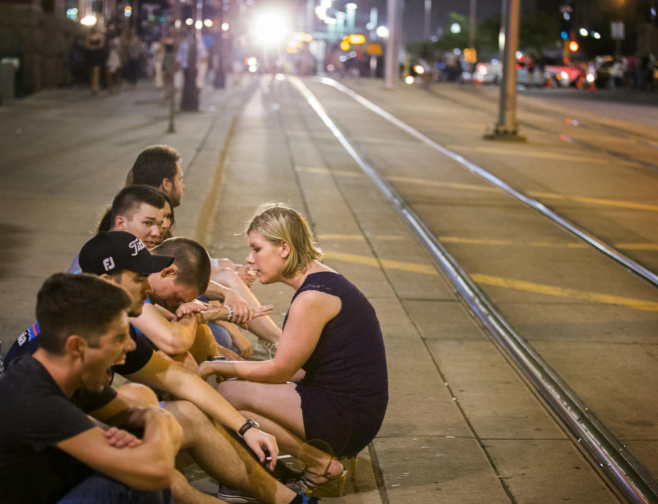 People sit on 5th Street outside Cowboy Jack's in the early morning after all the clubs have closed near the light rail line in downtown Minneapolis on Sunday, June 21, 2015. ] LEILA NAVIDI leila.navidi@startribune.com /
