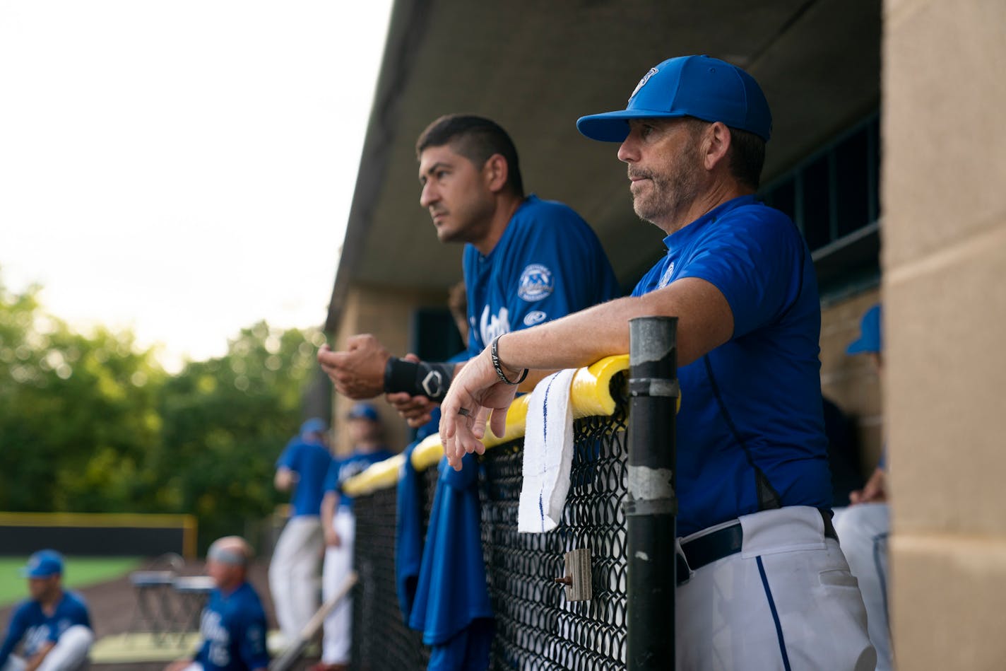 Minnetonka Millers manager Kevin Hoy, right, watched the team warm up from the dugout at Veteran's Field in Minnetonka, Minn., on Monday, July 6, 2020. At left is Minnetonka Millers player Joe Abellera. ] RENEE JONES SCHNEIDER renee.jones@startribune.com