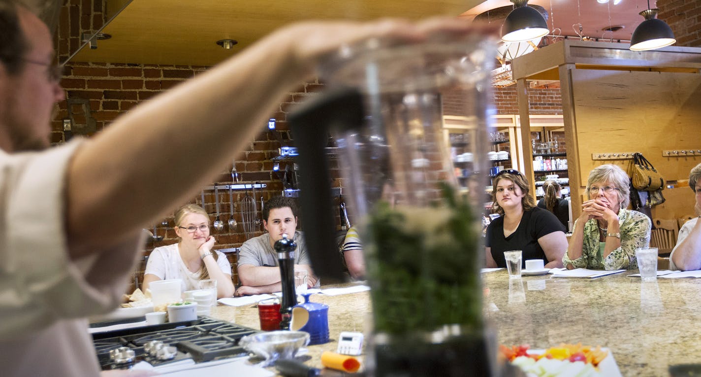 Wade Gregory, foreground, teaches a Lunch Counter demo class at Cooks of Crocus Hill in Stillwater June 27, 2014. Customers learn how to make recipes that they then enjoy for lunch. (Courtney Perry/Special to the Star Tribune)