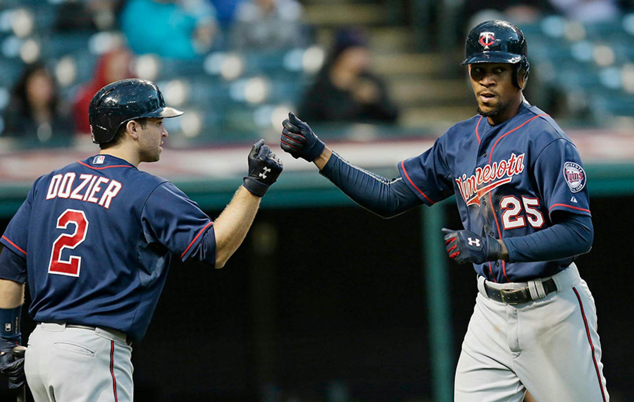 Minnesota Twinsí Byron Buxton (25) is congratulated by Brian Dozier (2) after Buxton hit a solo home run off Cleveland Indians relief pitcher Shawn Armstrong in the ninth inning of the first baseball game of a doubleheader, Wednesday, Sept. 30, 2015, in Cleveland. (AP Photo/Tony Dejak)