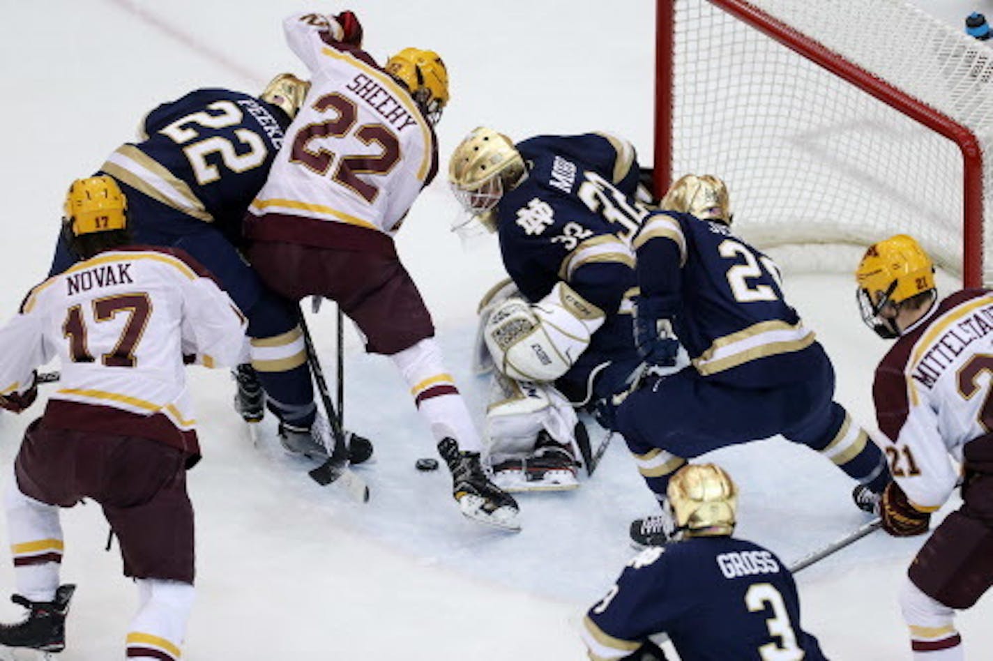 Minnesota Golden Gophers forward Tyler Sheehy (22) fought Notre Dame Fighting Irish defenseman Andrew Peeke (22) for the puck in front of Notre Dame Fighting Irish goaltender Cale Morris (32) in the second period. ] ANTHONY SOUFFLE ' anthony.souffle@startribune.com