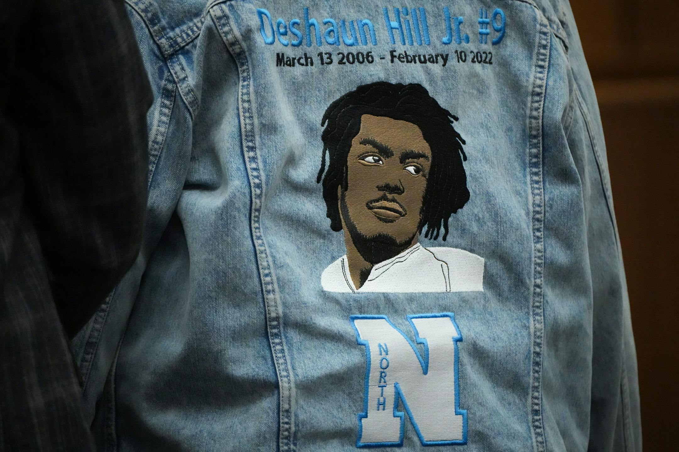 Deshaun Hill, Jr.'s mother, Tuesday Sheppard, wears a jacket with her son's name and likeness embroidered on it while she gives a victim impact statement.