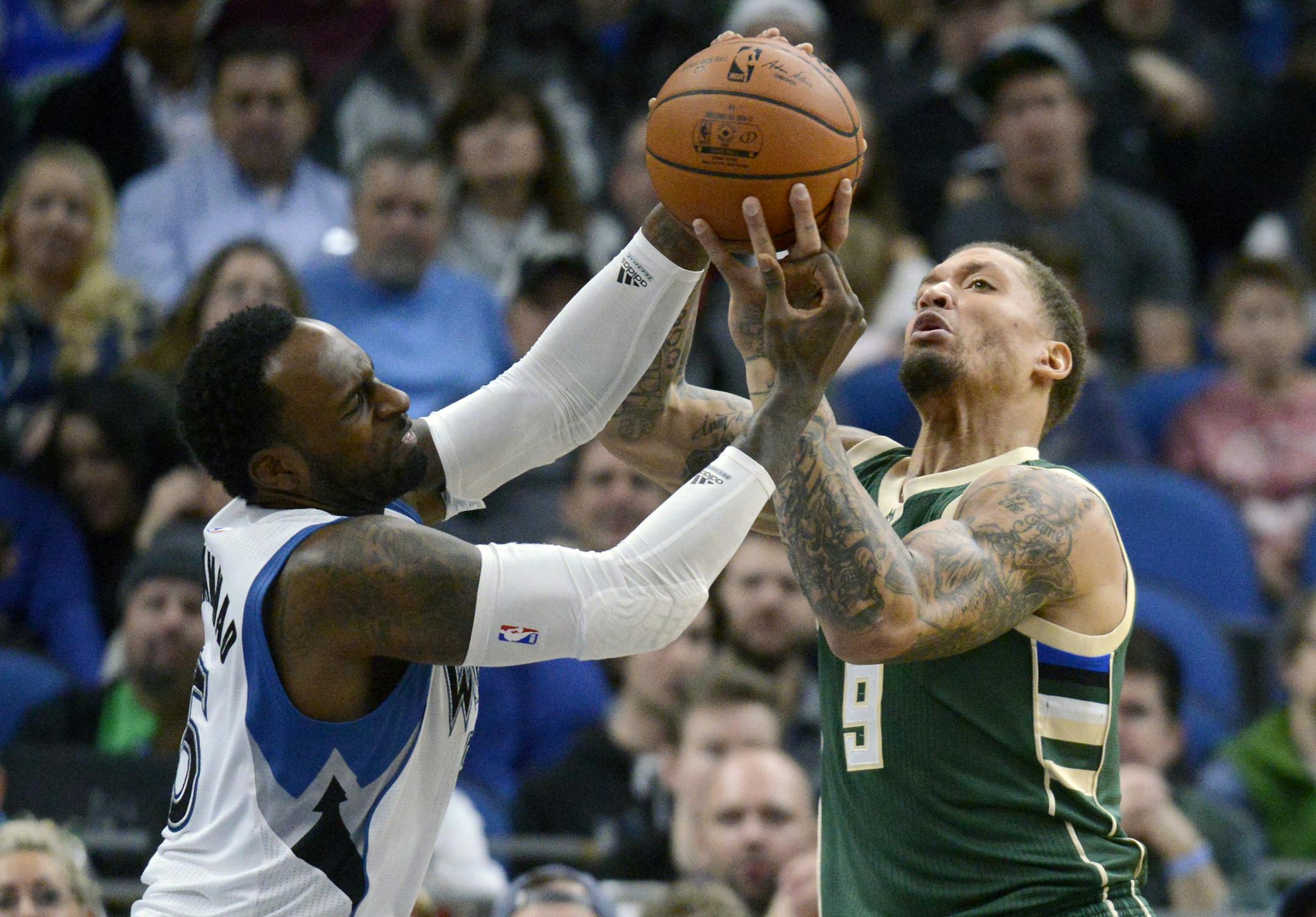 Minnesota Timberwolves forward Shabazz Muhammad goes for a rebound against Milwaukee Bucks forward Michael Beasley (9) during the first quarter of an NBA basketball game on Friday, Dec. 30, 2016, in Minneapolis. (AP Photo/Hannah Foslien)