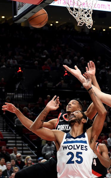 Minnesota Timberwolves guard Derrick Rose, front, battles for a rebound with Portland Trail Blazers guard CJ McCollum, back, during the first half of 