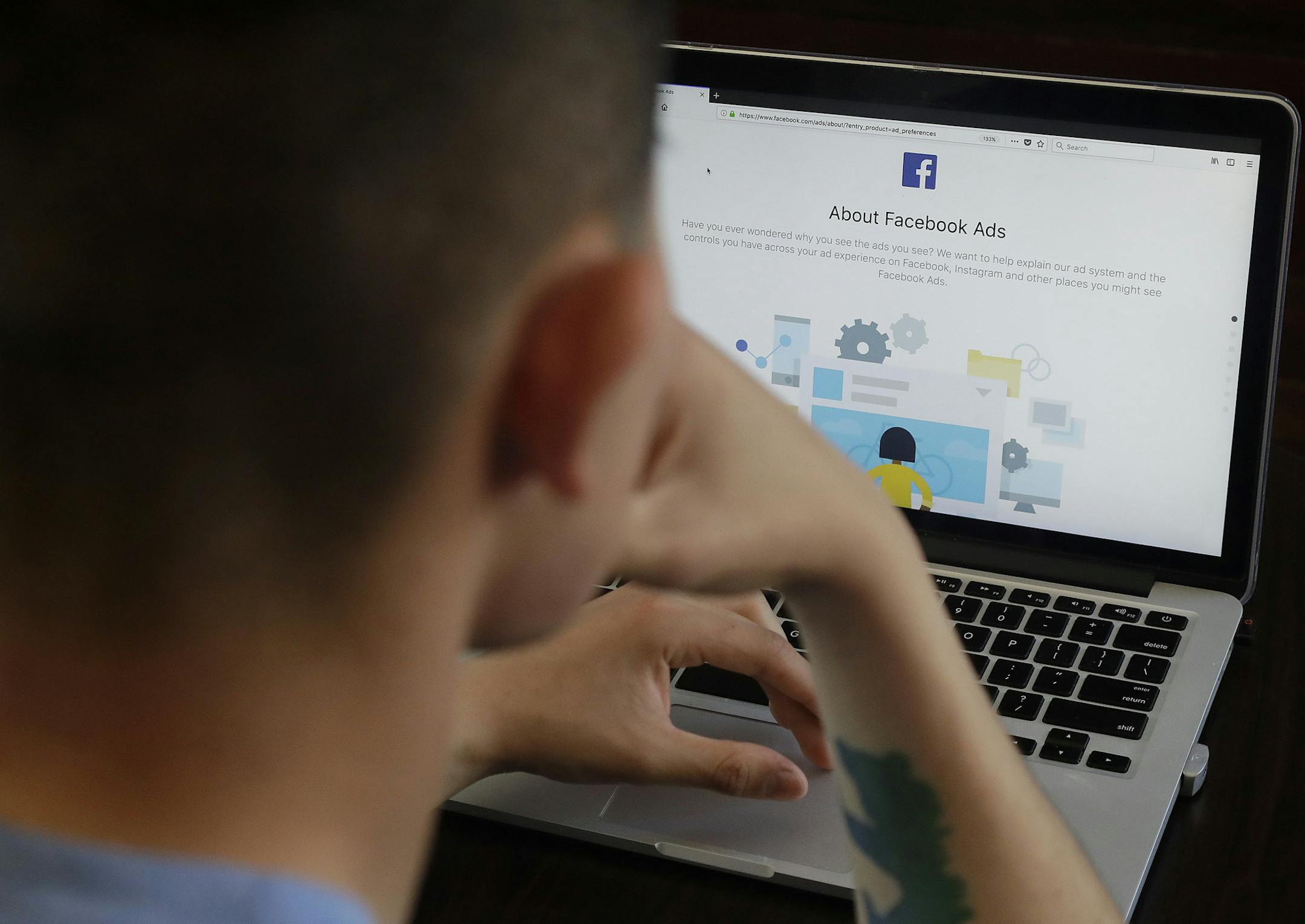 In this March 26, 2018 photo, a man poses for photos in front of a computer showing a Facebook ad preferences page in San Francisco. (AP Photo/Jeff Chiu) ORG XMIT: CAJC