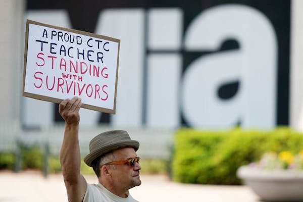 Andrew Erskine Wheeler, an acting instructor on staff at the Children's Theatre Company, held a sign as he stood in support of survivors during a prot