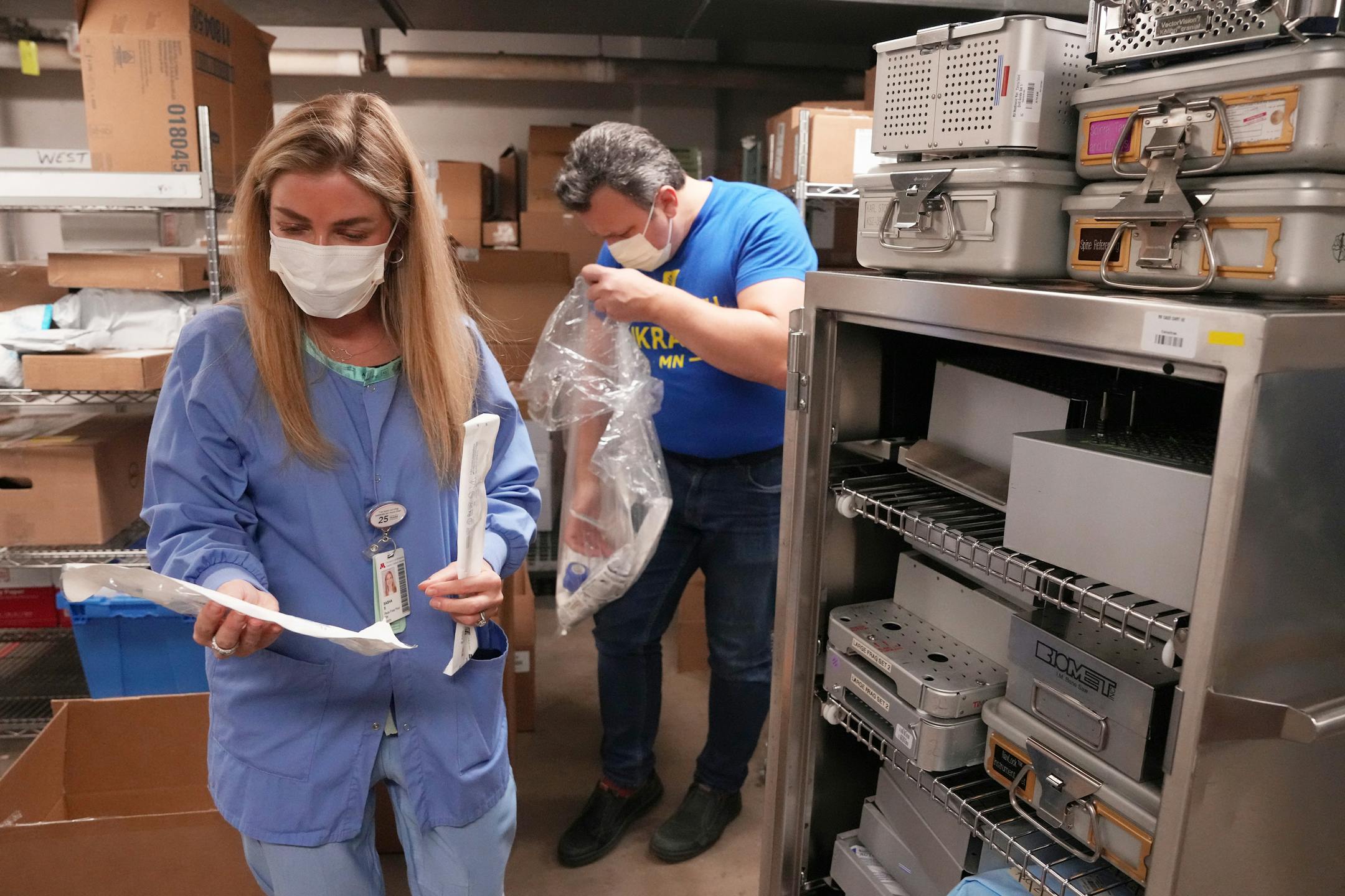 Sasha Sakurets, a Ukrainian American volunteer and nurse at M Health Fairview Masonic Children's Hospital, and Mykola Sarazhynskyy, a volunteer with Stand with Ukraine MN, sort through surplus orthopedic surgery instruments in the hospital's basement.