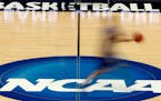 FILE - In this March 14, 2012, file photo, a player runs across the NCAA logo during practice in Pittsburgh. The NCAA is moving closer to permitting D