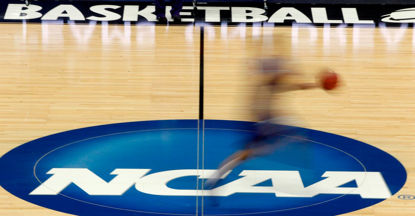 FILE - In this March 14, 2012, file photo, a player runs across the NCAA logo during practice in Pittsburgh. The NCAA is moving closer to permitting Division I college athletes to earn money from endorsements and sponsorship deals they can strike on their own. Recommendations for changes to NCAA rules that would permit athletes to earn money for their names, images and likeness are being reviewed by college sports administrators this week before being sent to the association's Board of Governors. (AP Photo/Keith Srakocic, File)