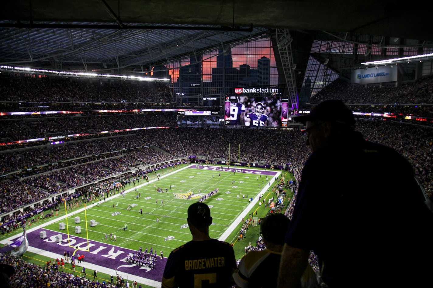 The sun sets behind a silhouette of the Minneapolis skyline as Vikings plays took the field during a game last season.