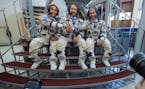 From left: Joe Acaba of NASA, Alexander Misurkin of Roscosmos, and Mark Vande Hei of NASA pose for a photograph for the press outside the Soyuz simula