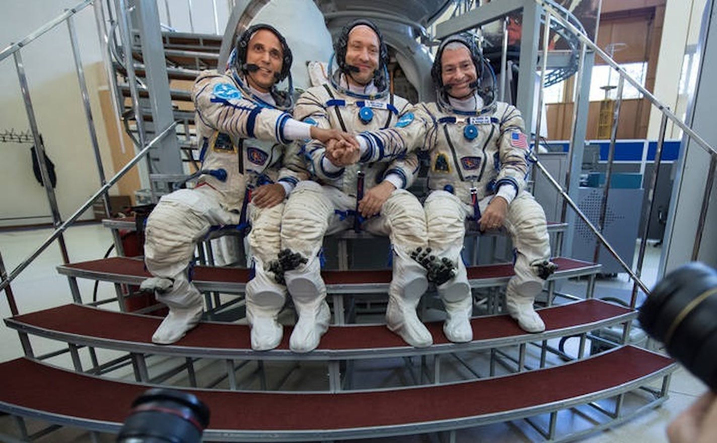 From left: Joe Acaba of NASA, Alexander Misurkin of Roscosmos, and Mark Vande Hei of NASA pose for a photograph for the press outside the Soyuz simulator ahead of their Soyuz qualification exams, Thursday, Aug. 31, 2017, at the Gagarin Cosmonaut Training Center in Star City, Russia.